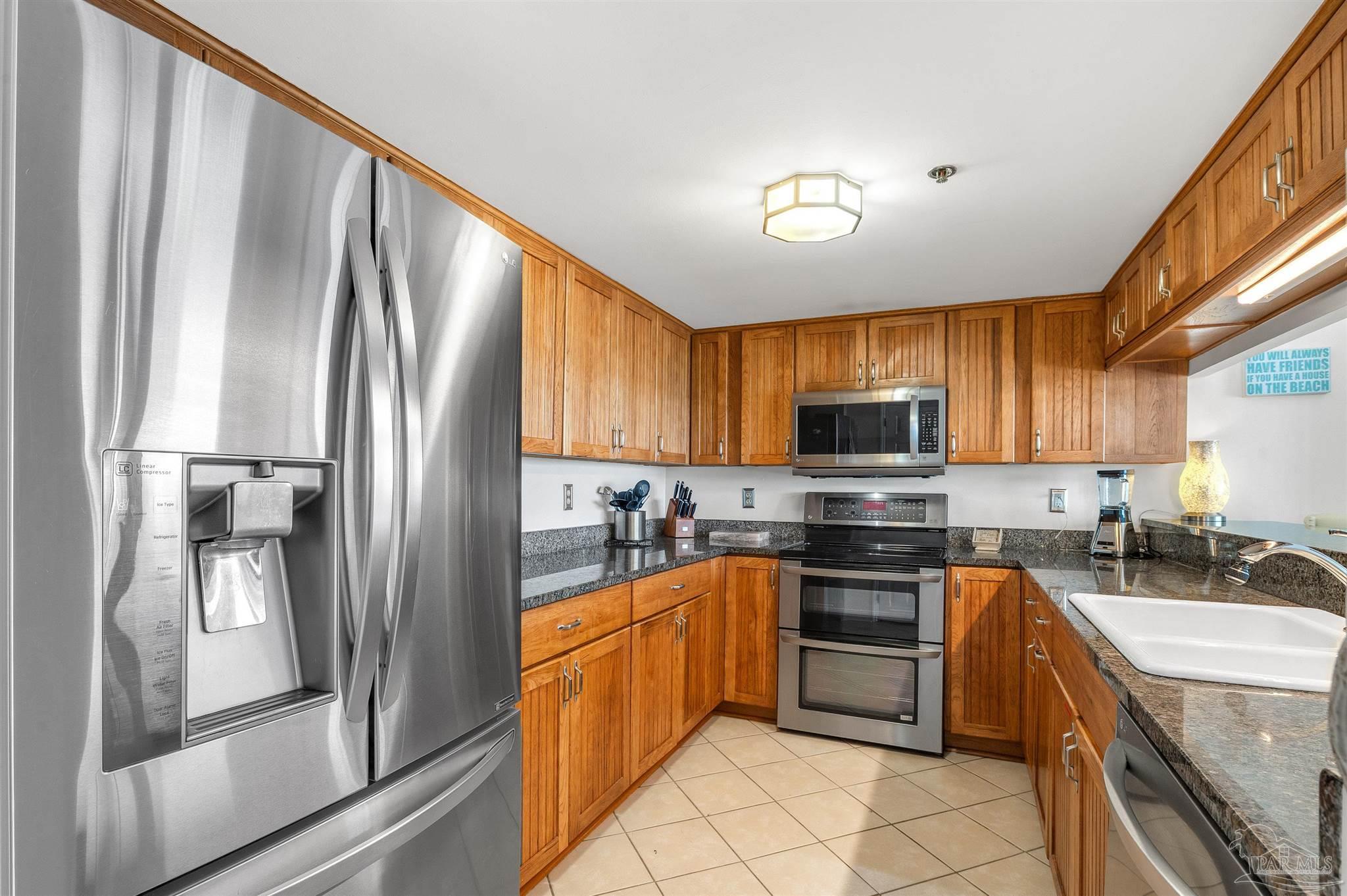 13817 Perdido Key Drive, Unit 501 Pensacola, FL 32507 - Photo 32 of 63 a kitchen with stainless steel appliances granite countertop a refrigerator stove and sink