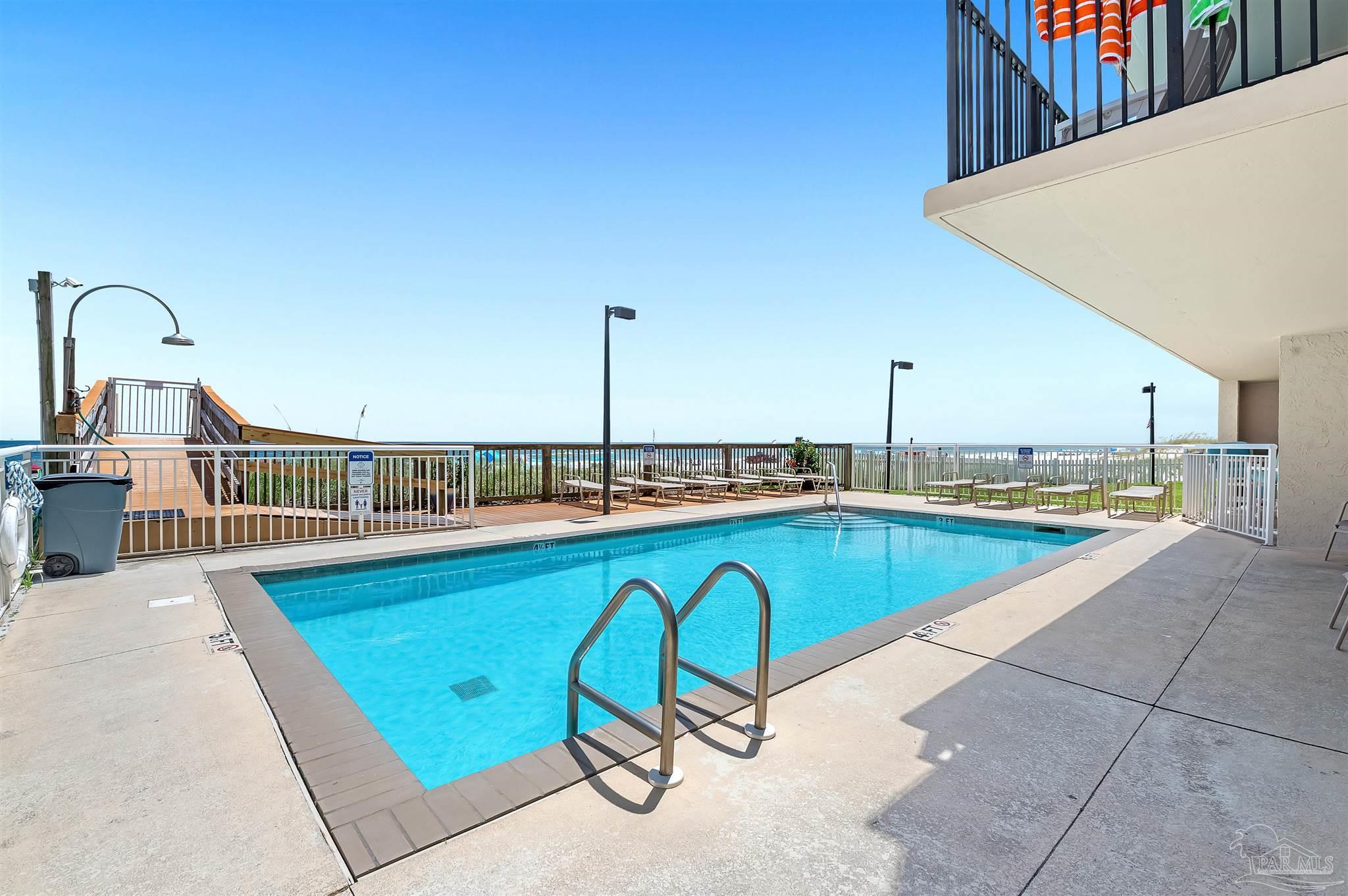 13817 Perdido Key Drive, Unit 501 Pensacola, FL 32507 - Photo 4 of 63 a view of a swimming pool with a lounge chair