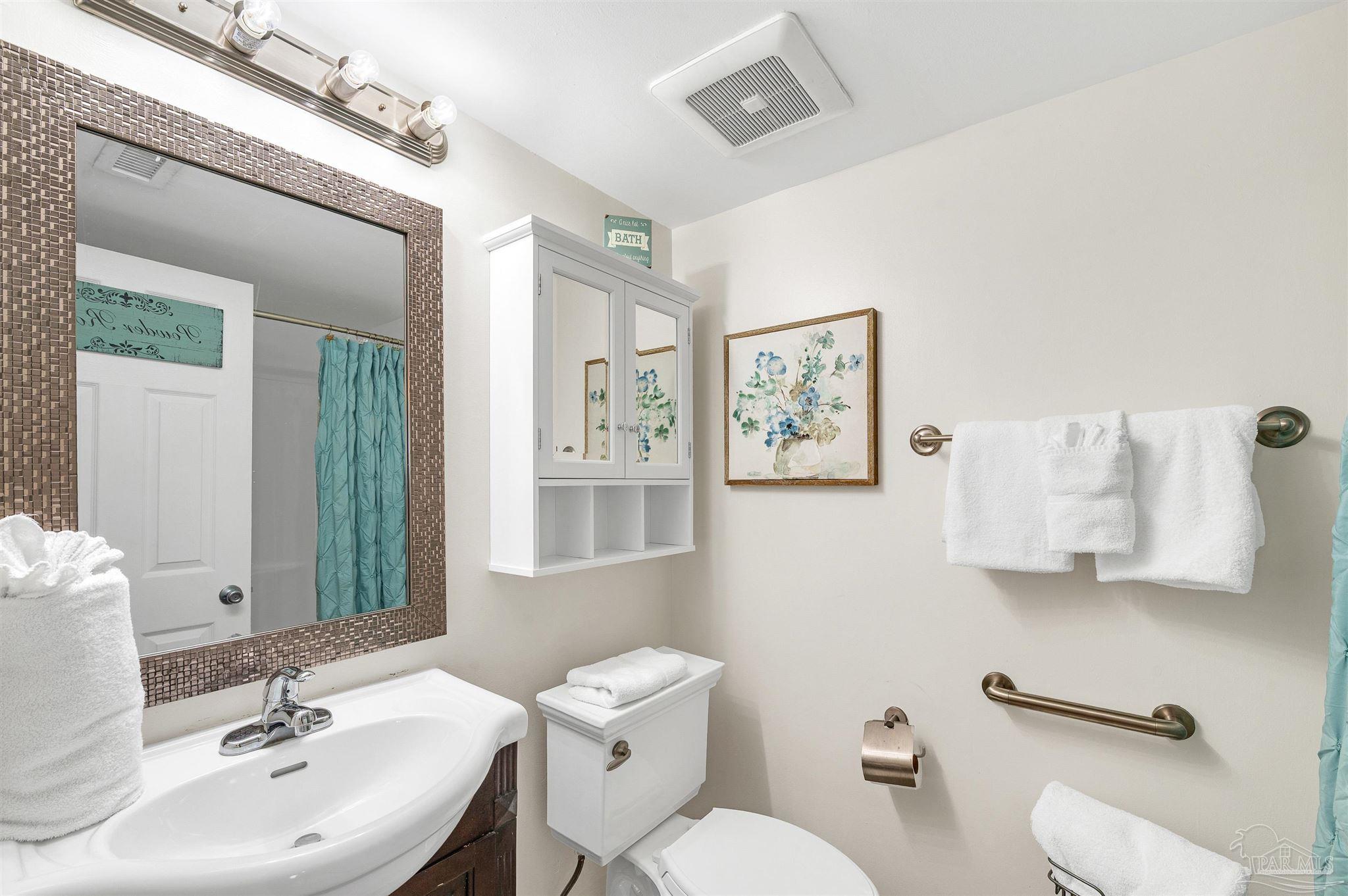 13817 Perdido Key Drive, Unit 501 Pensacola, FL 32507 - Photo 41 of 63 a bathroom with a toilet a sink and mirror