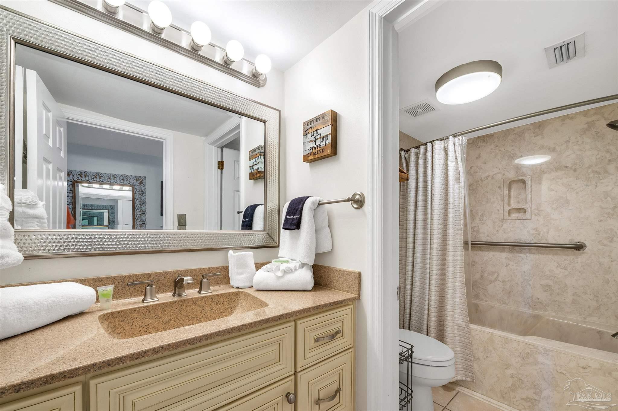 13817 Perdido Key Drive, Unit 501 Pensacola, FL 32507 - Photo 47 of 63 a bathroom with a granite countertop sink mirror toilet and shower
