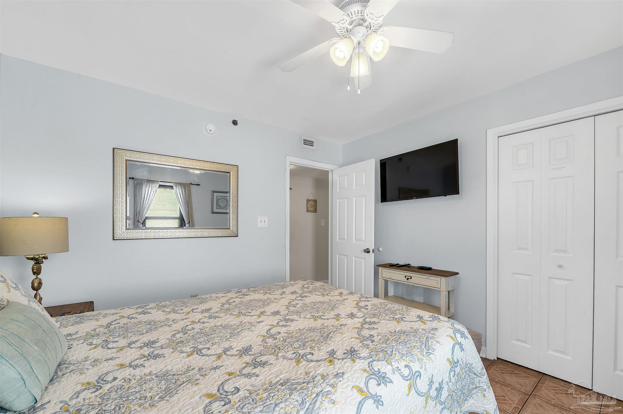 13817 Perdido Key Drive, Unit 501 Pensacola, FL 32507 - Photo 52 of 63 a bedroom with a bed and a flat screen tv