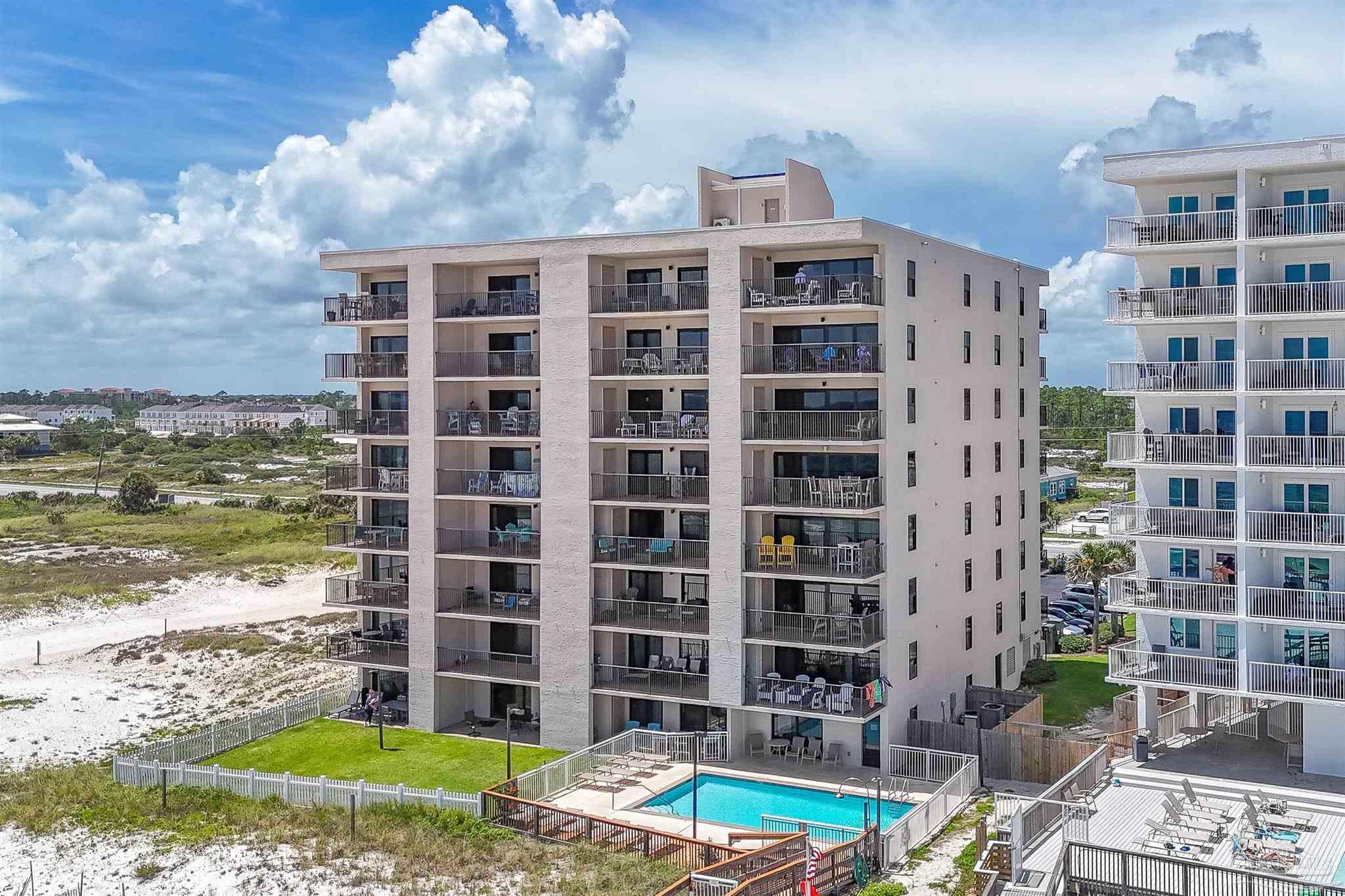 13817 Perdido Key Drive, Unit 501 Pensacola, FL 32507 - Photo 9 of 63 a front view of a building with a garden and plants