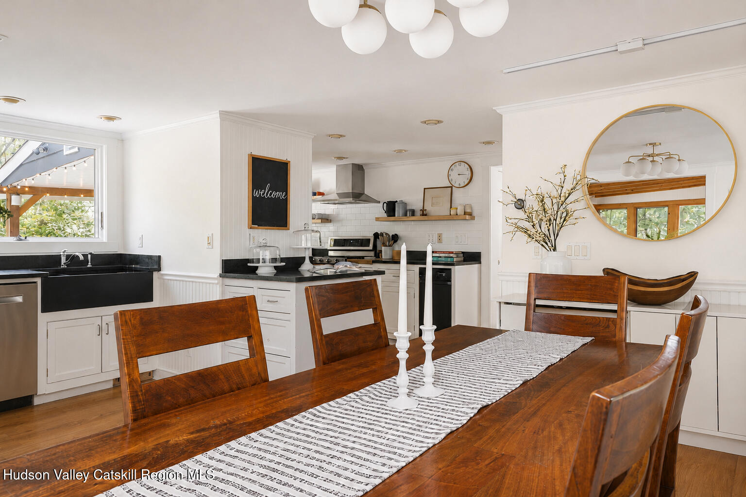 22 Old Mill Road Stephentown, NY 12169 - Photo 18 of 55 a kitchen with stainless steel appliances granite countertop a stove a refrigerator a sink a dining table and chairs with wooden floor