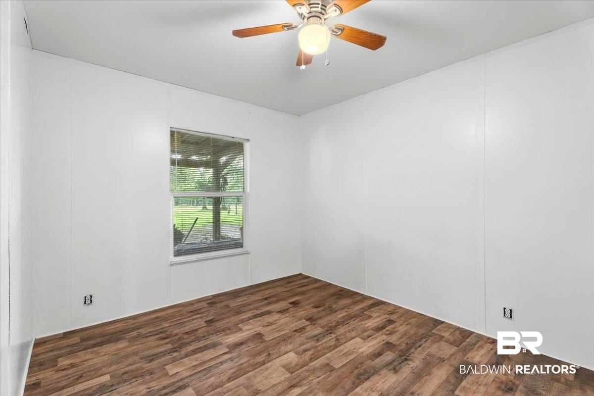 21011 River Road Robertsdale, AL 36567 - Photo 16 of 29 Room featuring wood-finish flooring, white paneling, and a ceiling fan with integrated lighting