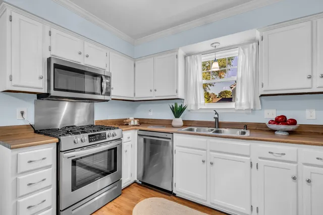 a kitchen with cabinets appliances a sink and a microwave