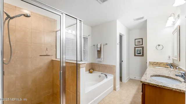 a bathroom with a granite countertop sink and a bathtub
