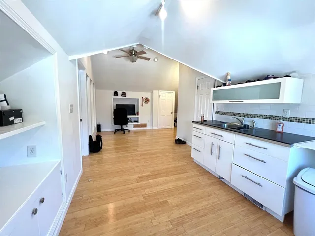 a large white kitchen with stainless steel appliances a large counter top a stove and a refrigerator