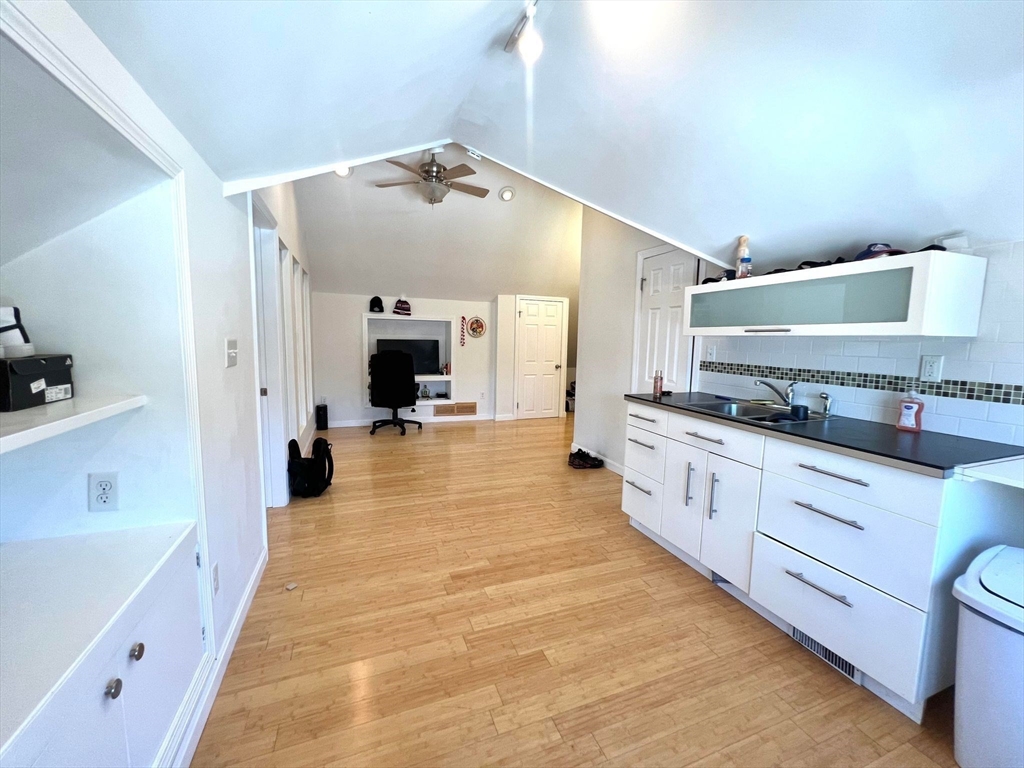 a large white kitchen with stainless steel appliances a large counter top a stove and a refrigerator