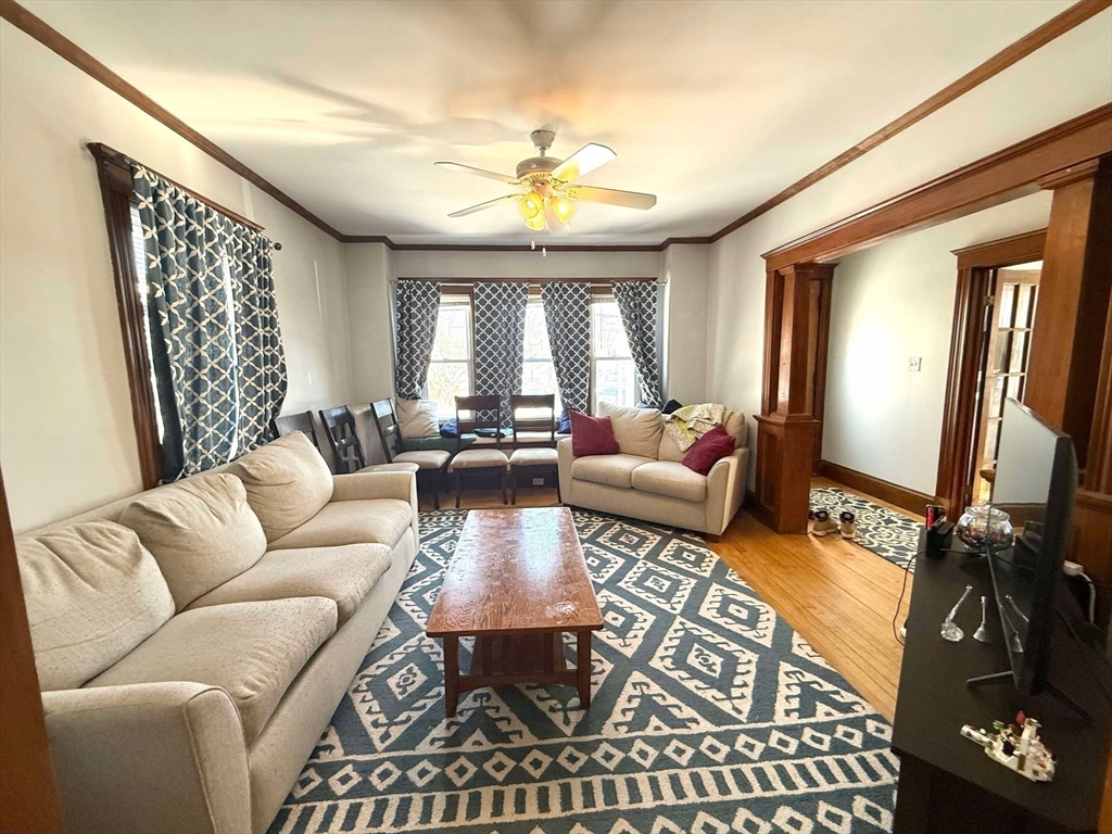 41 Woodward Avenue, Unit 2 Quincy, MA 02169 - Photo 12 of 27 a living room with furniture a chandelier and a large window