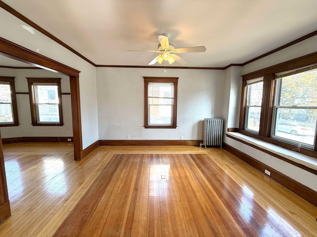 41 Woodward Avenue, Unit 2 Quincy, MA 02169 - Photo 18 of 27 a view of an empty room with wooden floor fireplace and a window