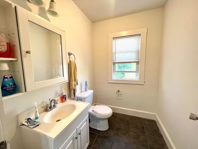 a bathroom with a sink vanity mirror and toilet