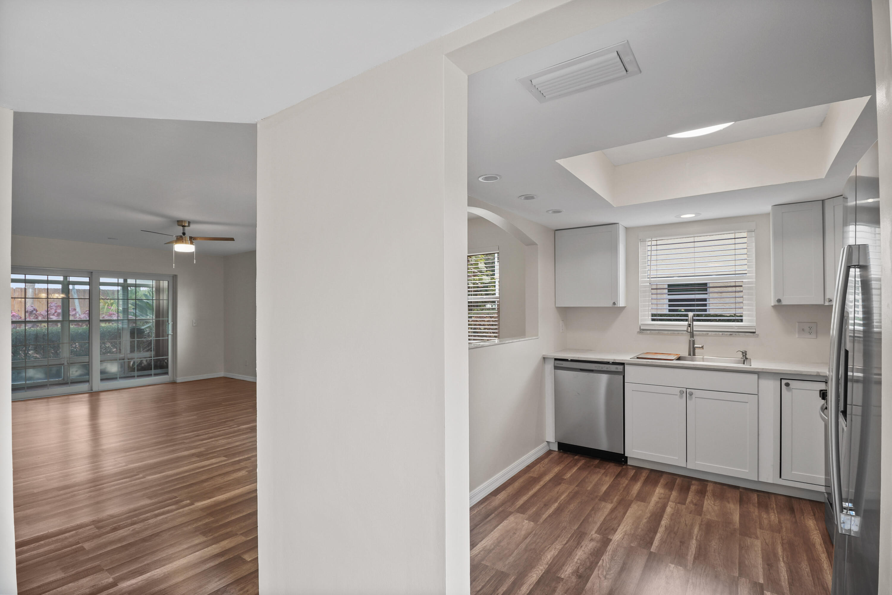2950 Southeast Ocean Boulevard, Unit 1304 Stuart, FL 34996 - Photo 12 of 35 a view of a kitchen from the hallway with a sink and wooden floor