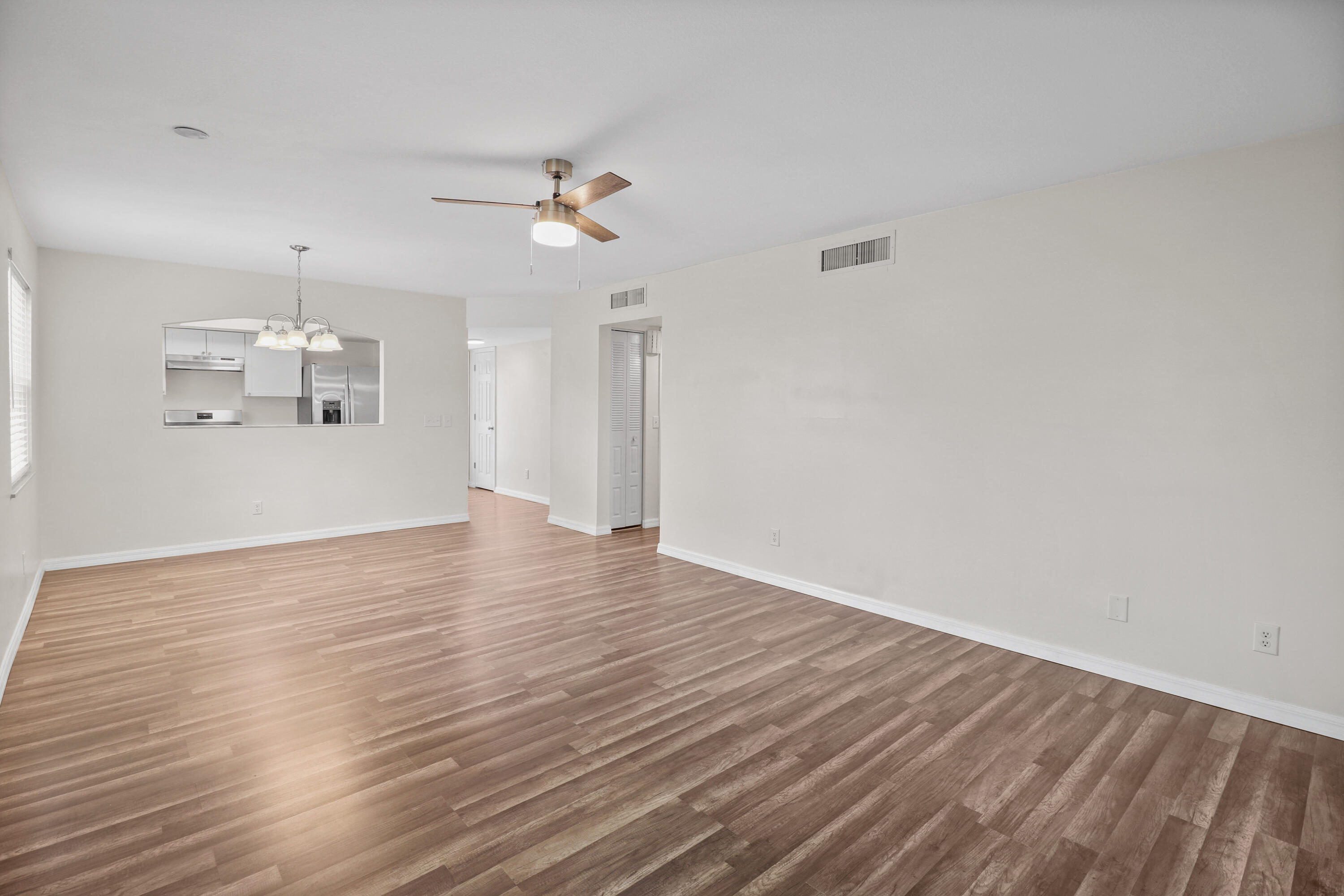 2950 Southeast Ocean Boulevard, Unit 1304 Stuart, FL 34996 - Photo 19 of 35 a view of a room with wooden floor and ceiling fan