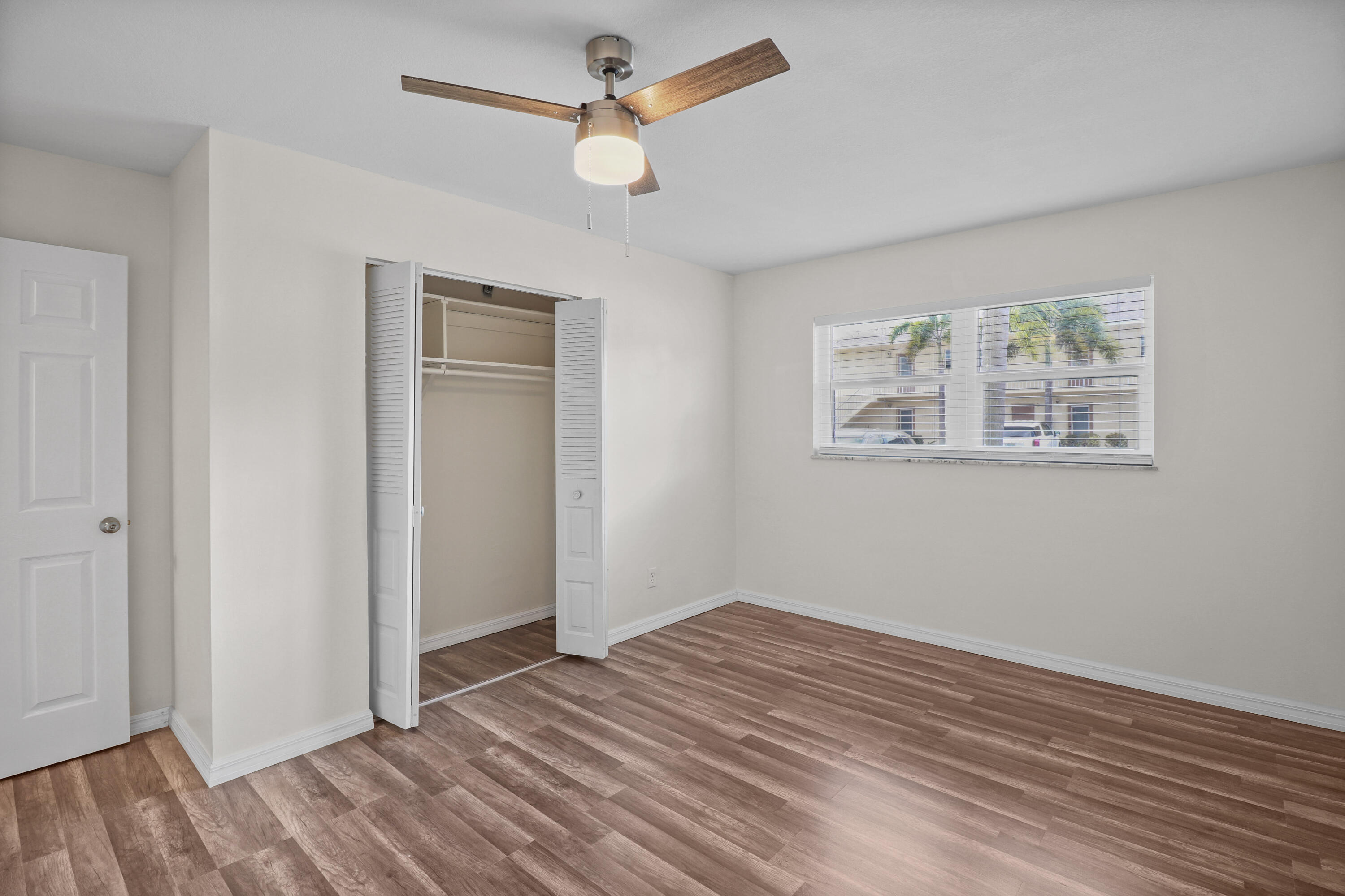 2950 Southeast Ocean Boulevard, Unit 1304 Stuart, FL 34996 - Photo 22 of 35 a view of a bedroom with wooden floor and ceiling fan