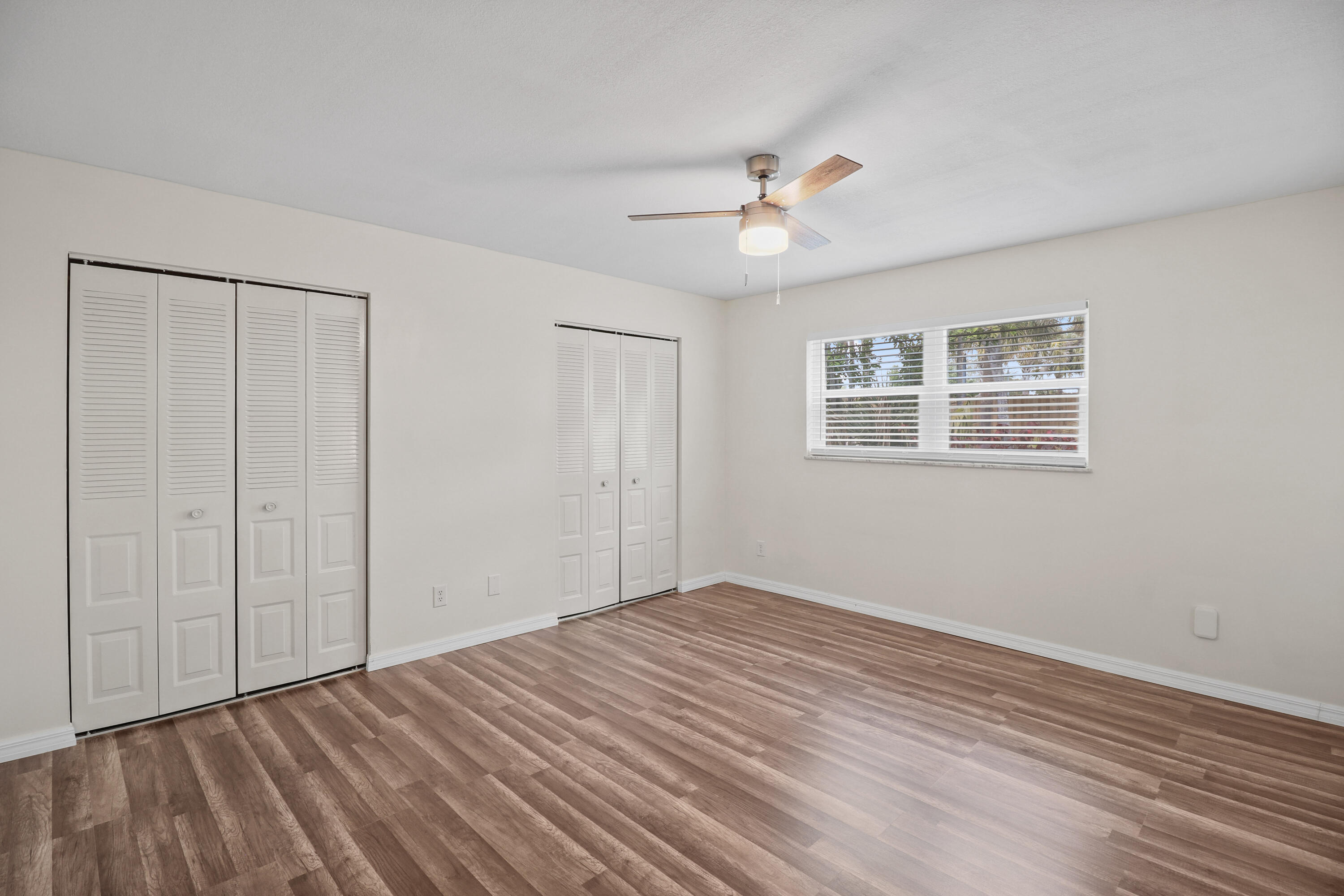 2950 Southeast Ocean Boulevard, Unit 1304 Stuart, FL 34996 - Photo 23 of 35 a view of an empty room with wooden floor and a ceiling fan
