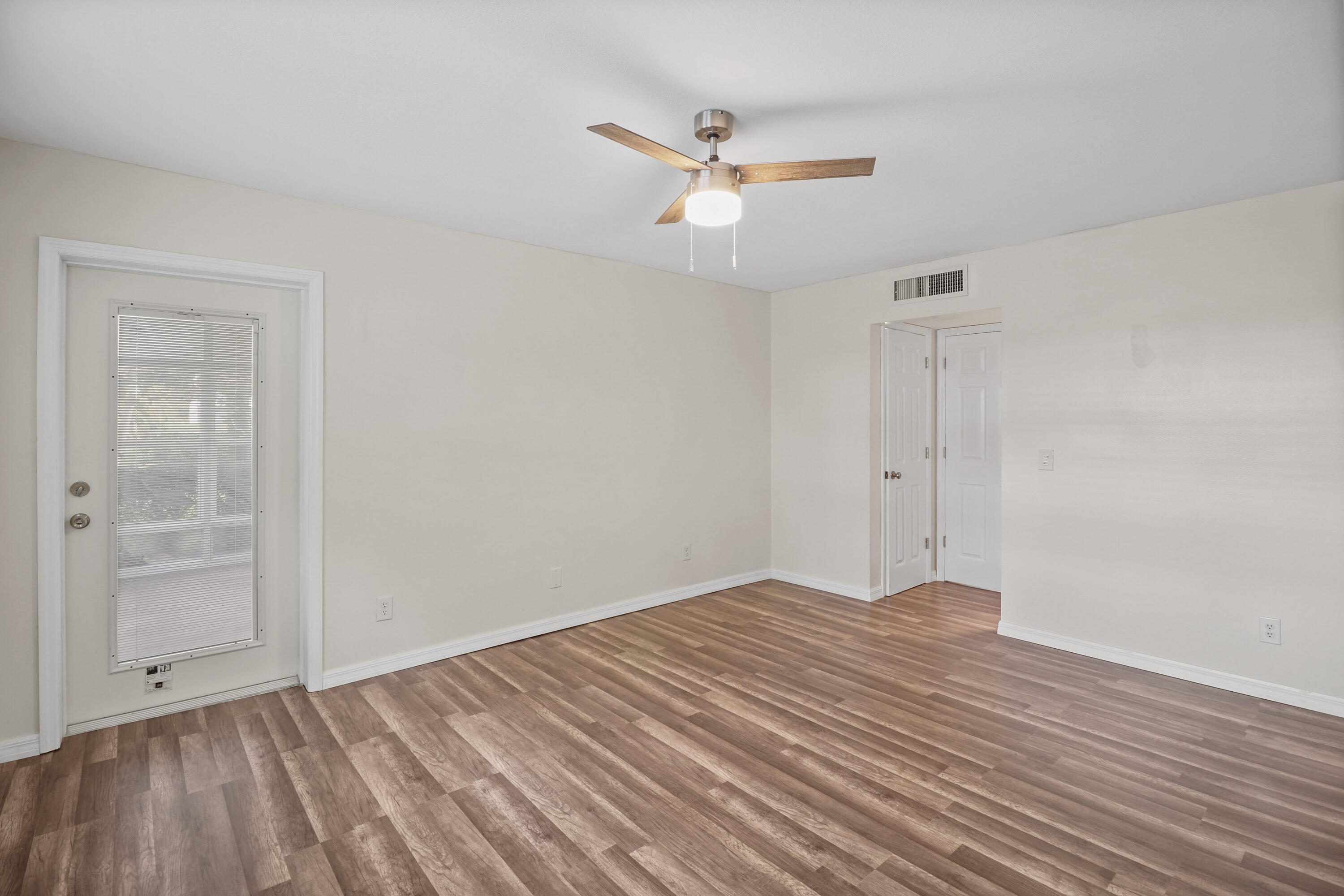 2950 Southeast Ocean Boulevard, Unit 1304 Stuart, FL 34996 - Photo 24 of 35 a view of an empty room with wooden floor and a ceiling fan