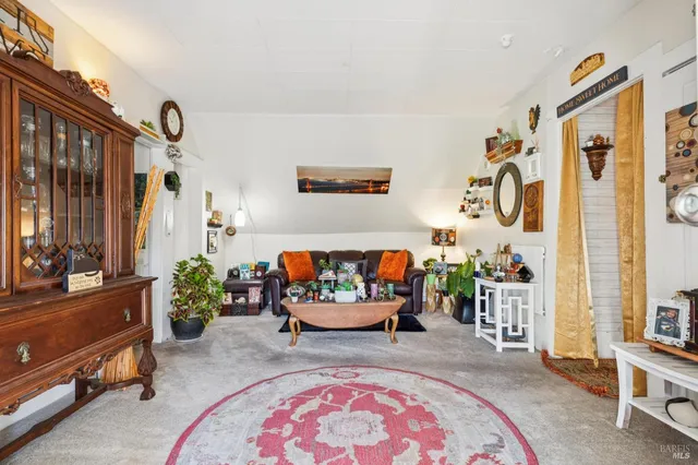 a backyard of a house with potted plants and large tree