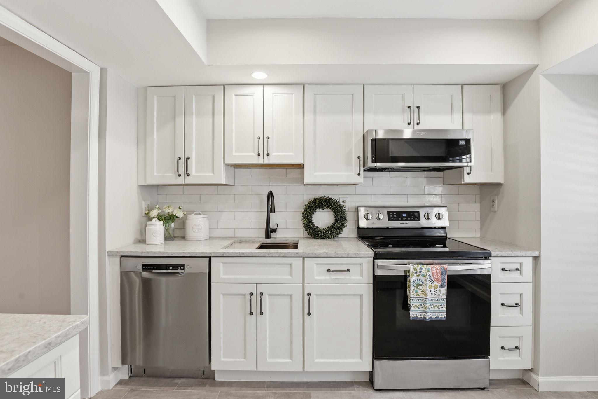 2544 South Walter Reed Drive, Unit B Arlington, VA 22206 - Photo 3 of 28 a kitchen with stainless steel appliances granite countertop a stove a sink and a microwave