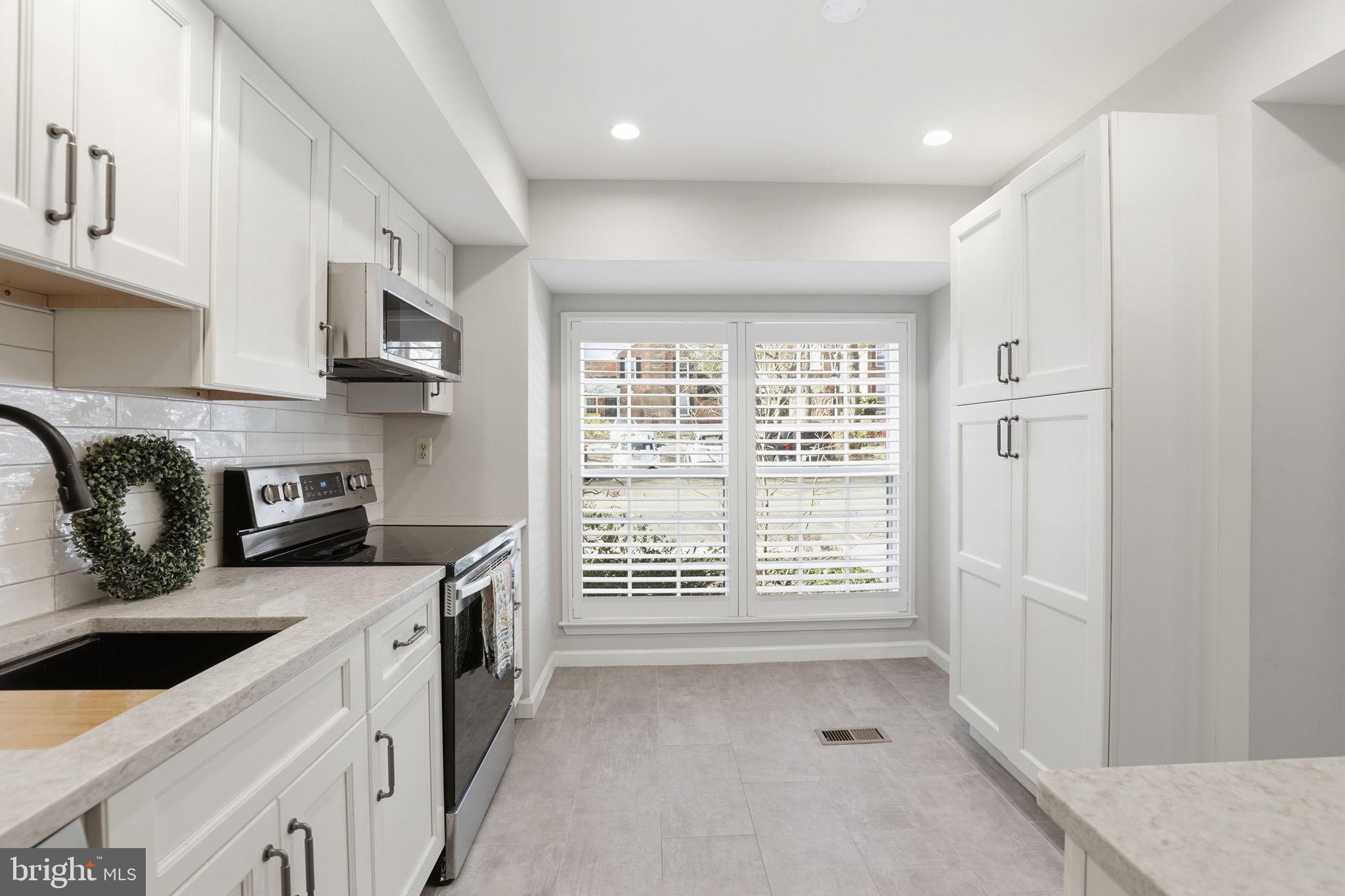 2544 South Walter Reed Drive, Unit B Arlington, VA 22206 - Photo 5 of 28 a kitchen with stainless steel appliances granite countertop a stove a sink and a refrigerator