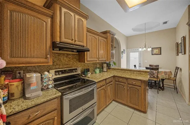 a kitchen with stainless steel appliances granite countertop a sink stove and cabinets