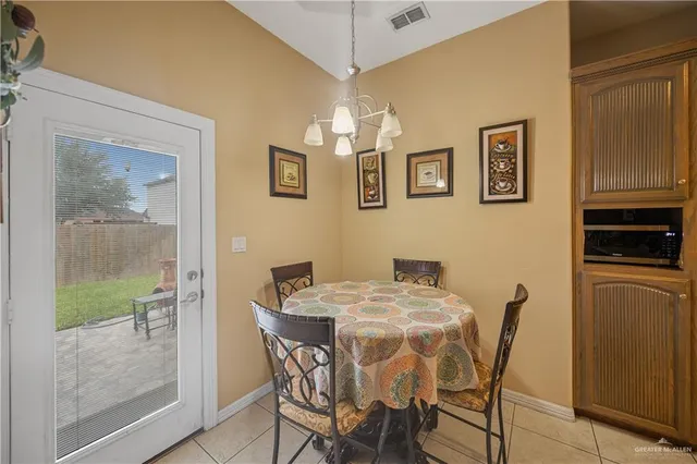 a view of a dining room with furniture and a chandelier