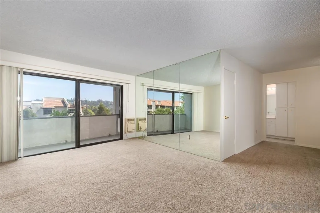 an empty room with sliding glass door and glass door