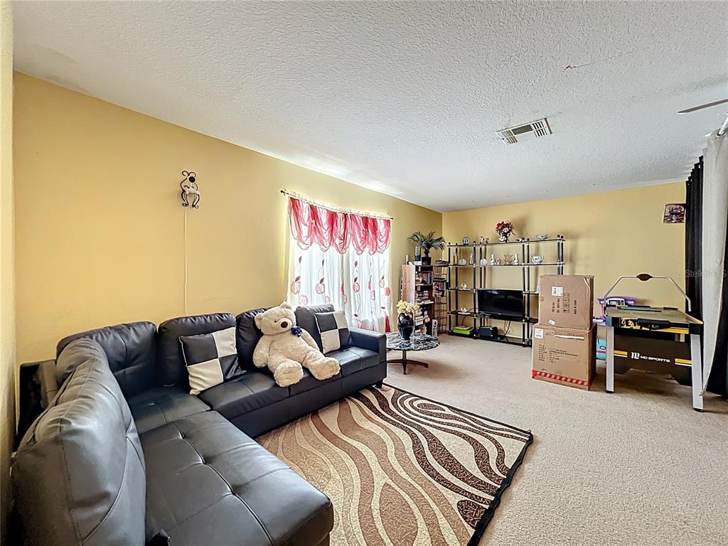 7939 Riffle Lane Orlando, FL 32818 - Photo 38 of 52 a living room with furniture kitchen view and a flat screen tv
