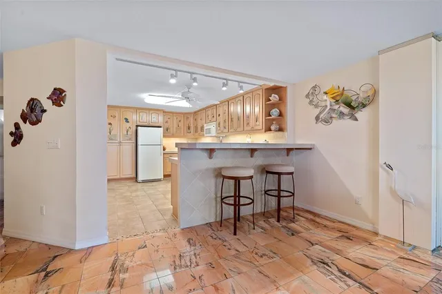 a kitchen with a refrigerator a stove top oven and white cabinets