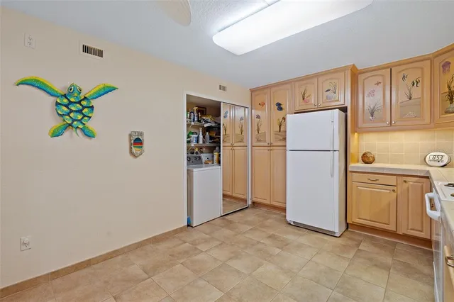 a kitchen with a sink a refrigerator and cabinets