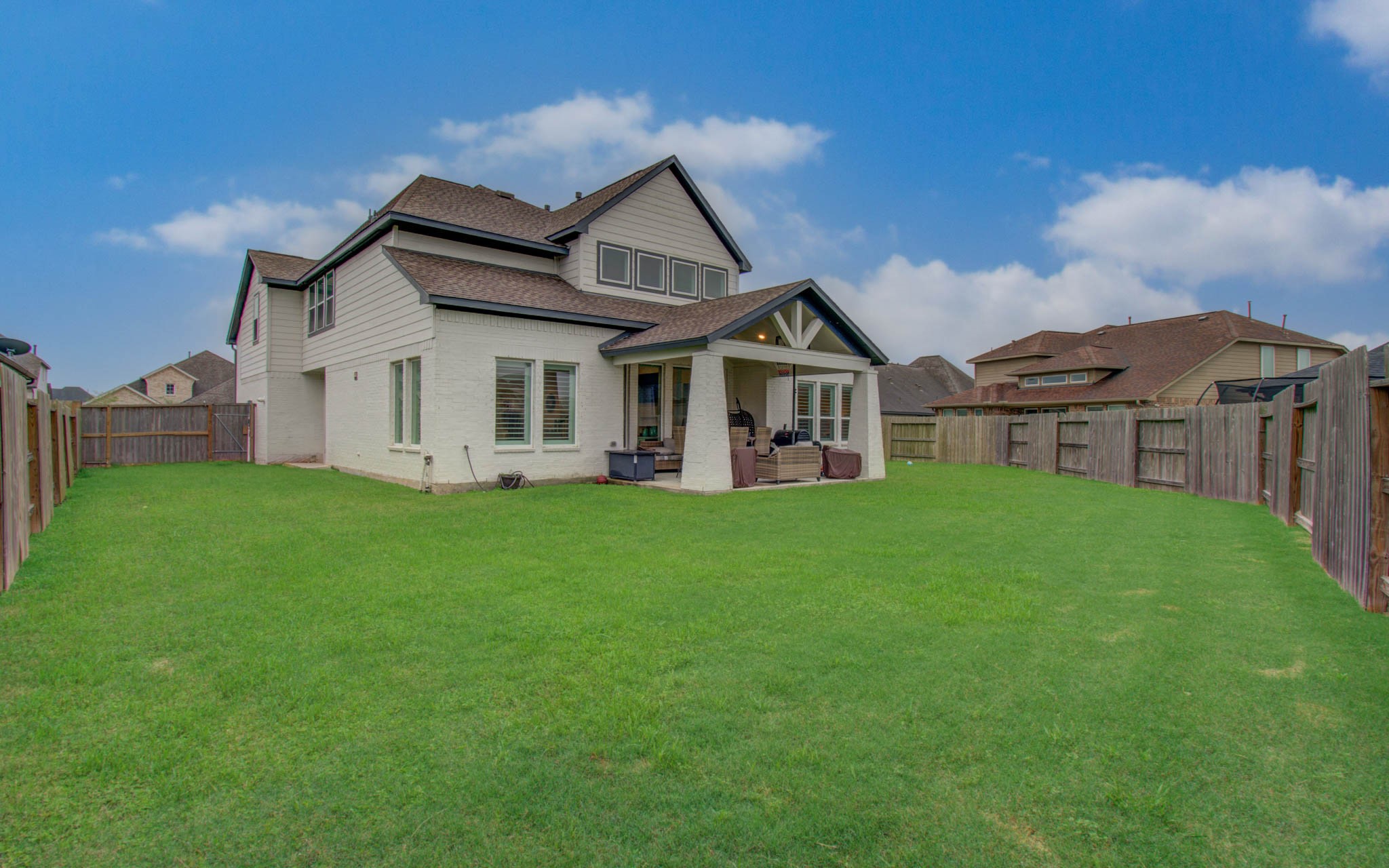 4211 Limestone Terrace Manvel, TX 77578 - Photo 32 of 33 Spacious backyard with lush green lawn, fenced for privacy. The house features a covered patio area, perfect for outdoor relaxation and entertaining.