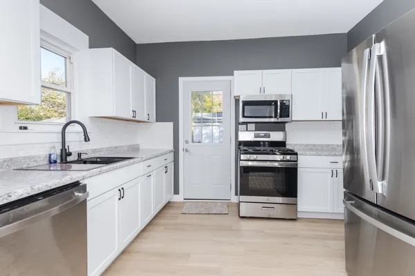 a kitchen with a refrigerator stove and wooden cabinets
