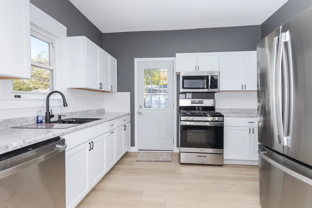 a kitchen with a refrigerator stove and wooden cabinets