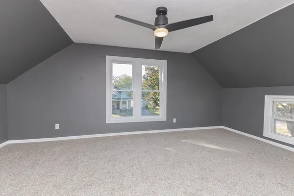 an empty room with chandelier fan