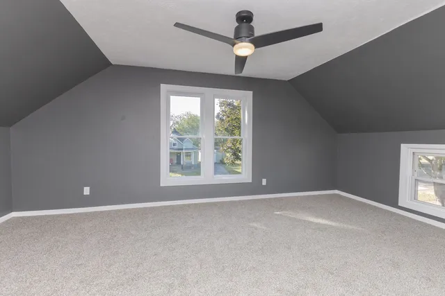 an empty room with chandelier fan