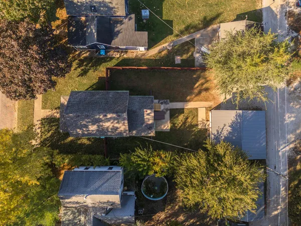 an aerial view of a house with a yard and wooden fence