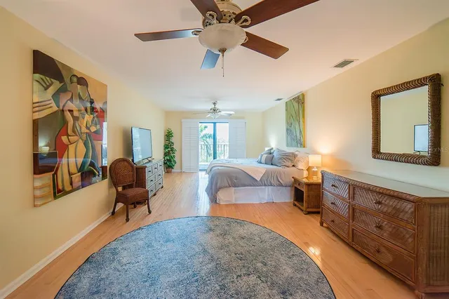 a bedroom with a large bed a flat tv screen and dresser