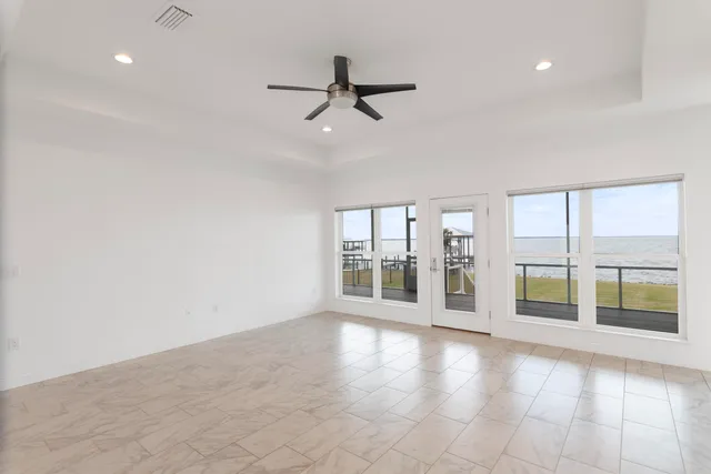 an empty room with wooden floor and a ceiling fan
