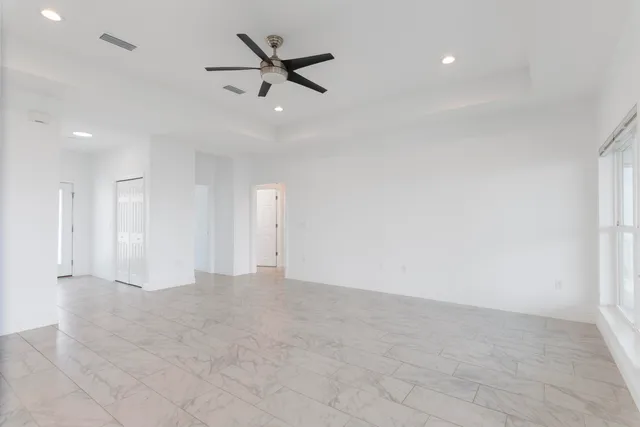 a large kitchen with stainless steel appliances a large counter top a stove and a refrigerator