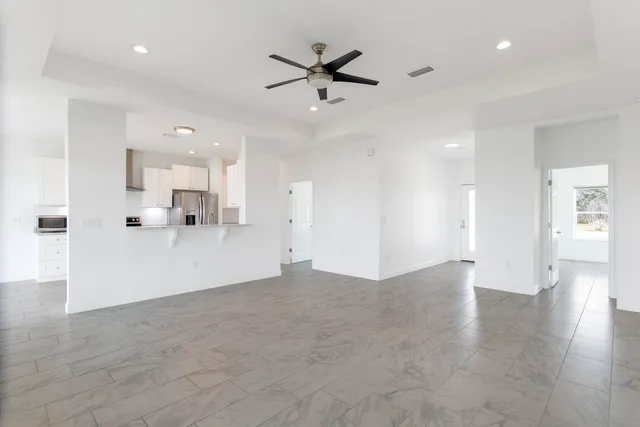 a large kitchen with a large counter top a sink stainless steel appliances and cabinets