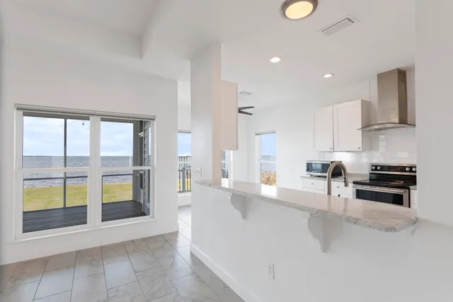 a kitchen with a sink dishwasher a stove and white cabinets