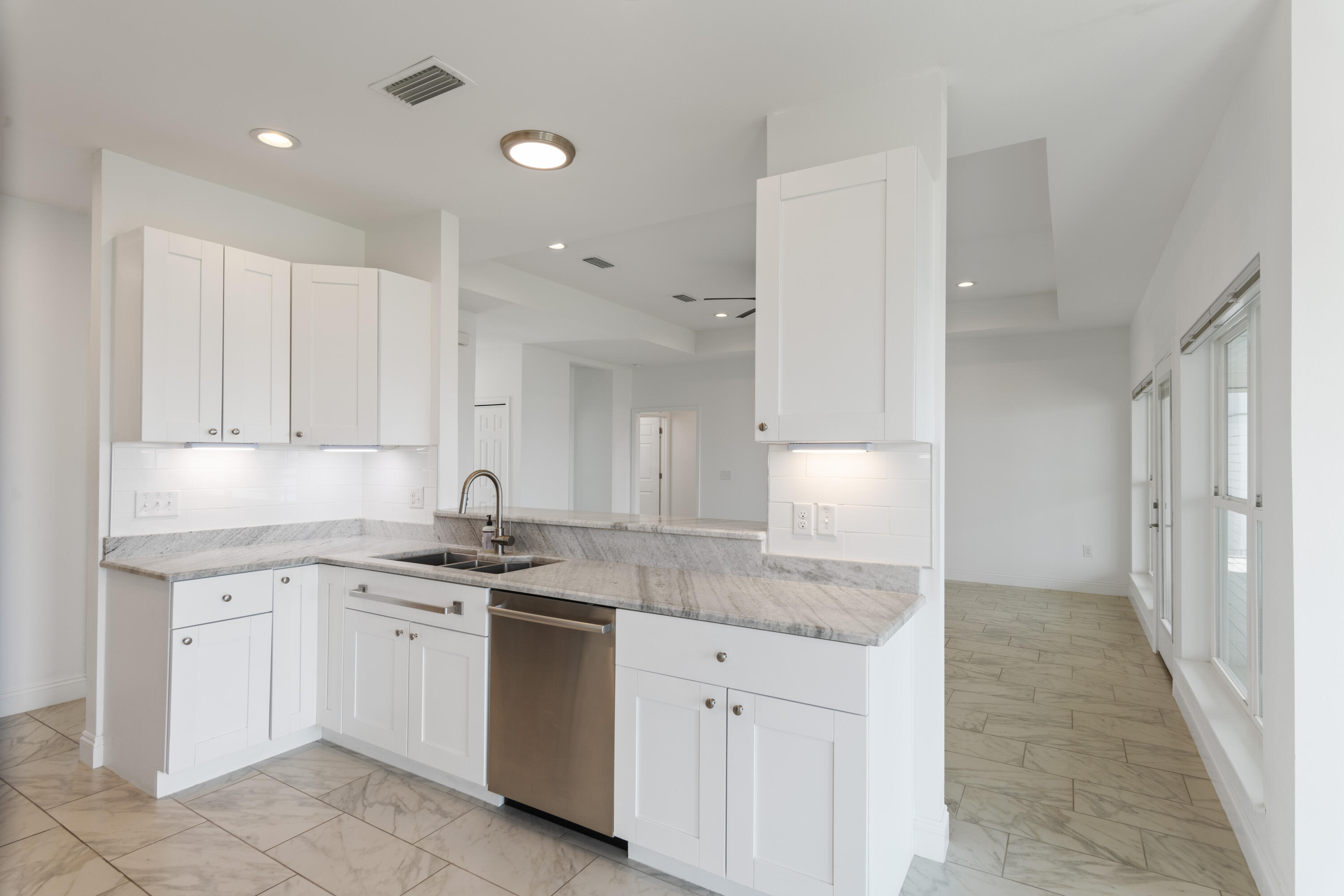 10 South Sunset Harbour Freeport, FL 32439 - Photo 23 of 57 a kitchen with a sink dishwasher a stove and white cabinets