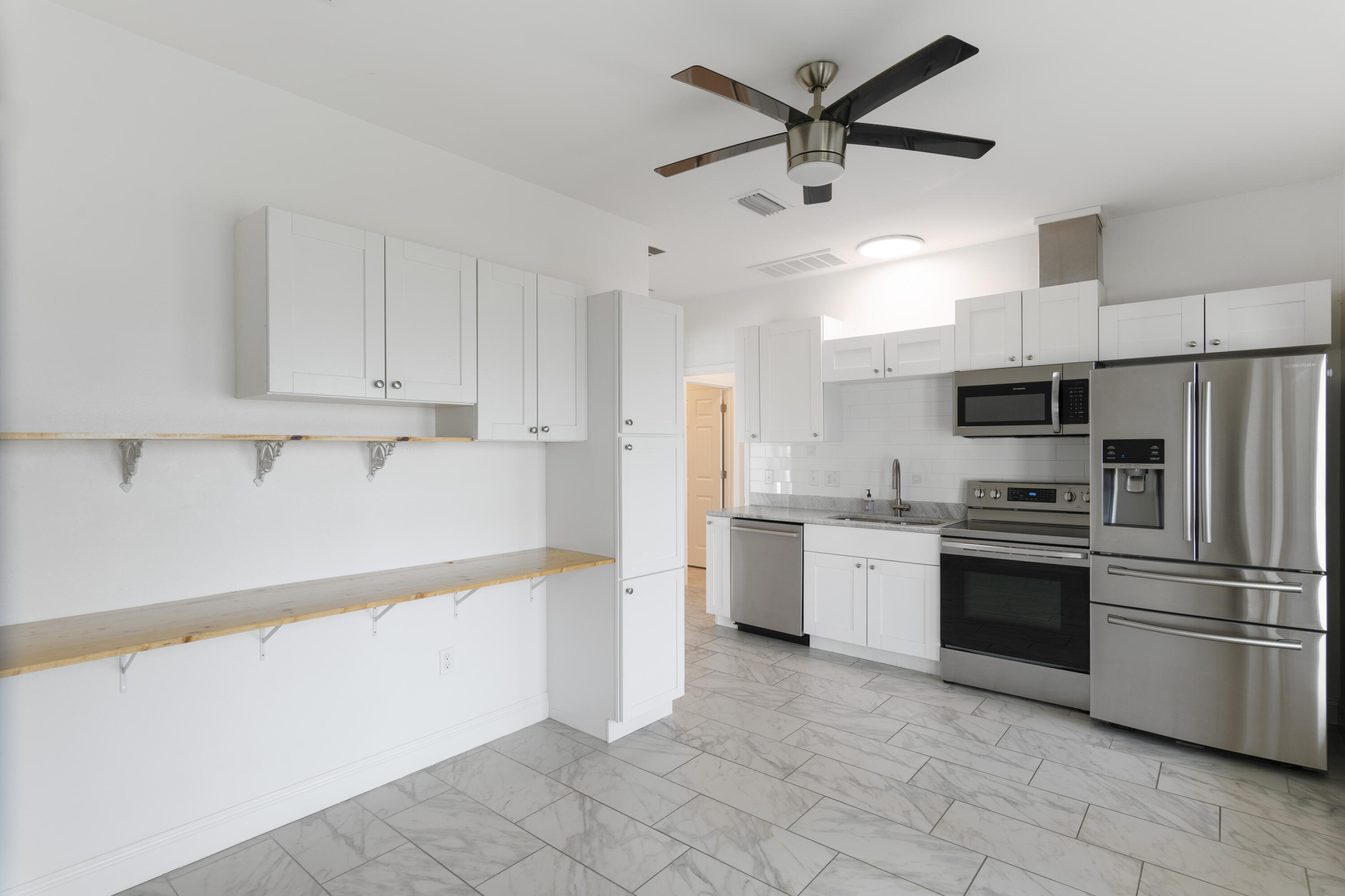 10 South Sunset Harbour Freeport, FL 32439 - Photo 27 of 57 a kitchen with granite countertop a refrigerator oven a sink and white cabinets