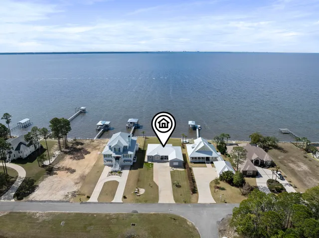 a view of an empty room with a window and a kitchen view