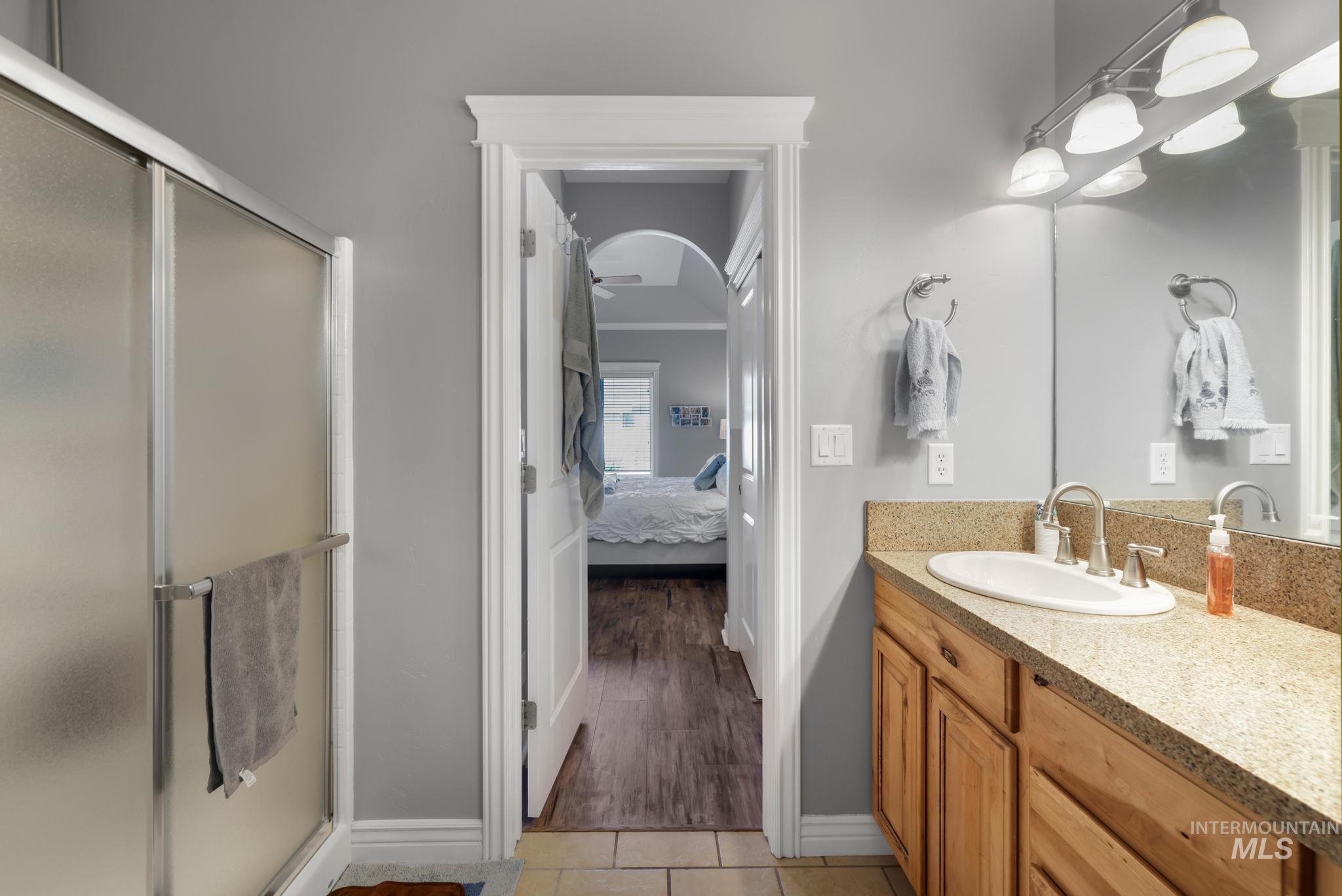 467 Wildrose Loop Twin Falls, ID 83301 - Photo 27 of 46 Bathroom featuring a single vanity with wood cabinetry and a light-toned countertop, an integrated sink, and a framed mirror with overhead lighting