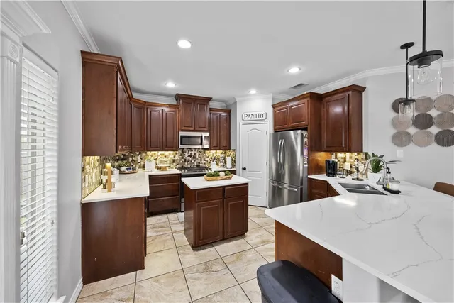 a kitchen with stainless steel appliances kitchen island granite countertop a refrigerator and a sink