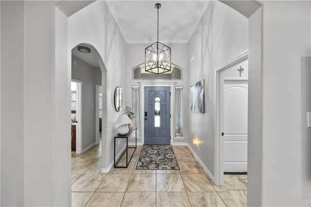 a view of a hallway with wooden floor and a chandelier