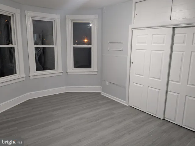 an empty room with wooden floor and closet