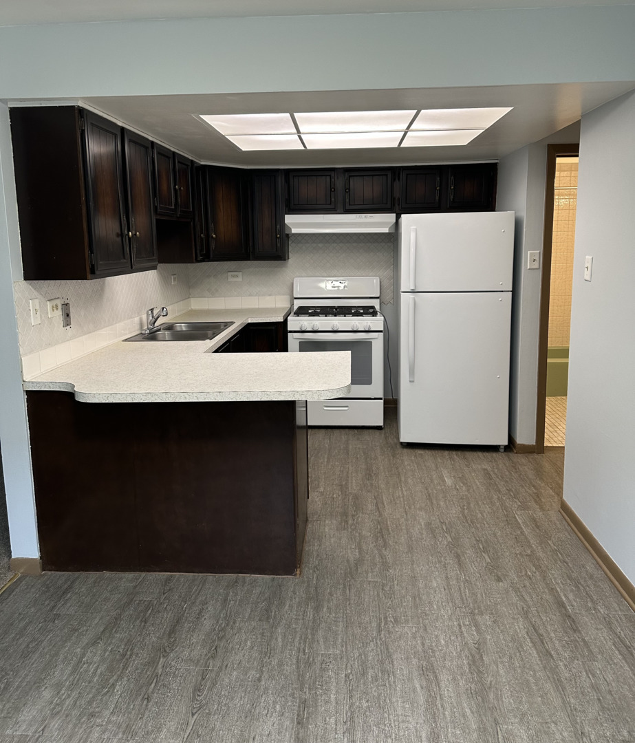 8020 West 84th Street Justice, IL 60458 - Photo 2 of 17 a kitchen with stainless steel appliances a stove a microwave and a hard wood floor