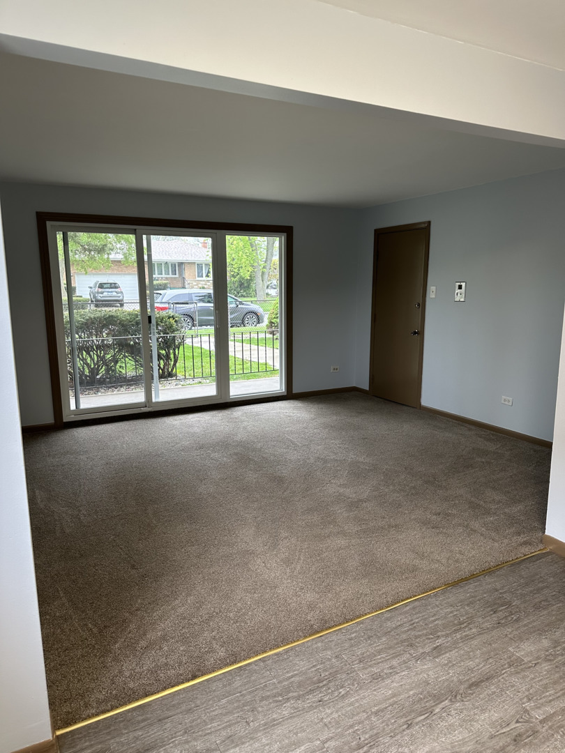 8020 West 84th Street Justice, IL 60458 - Photo 4 of 17 an empty room with large windows and garden view