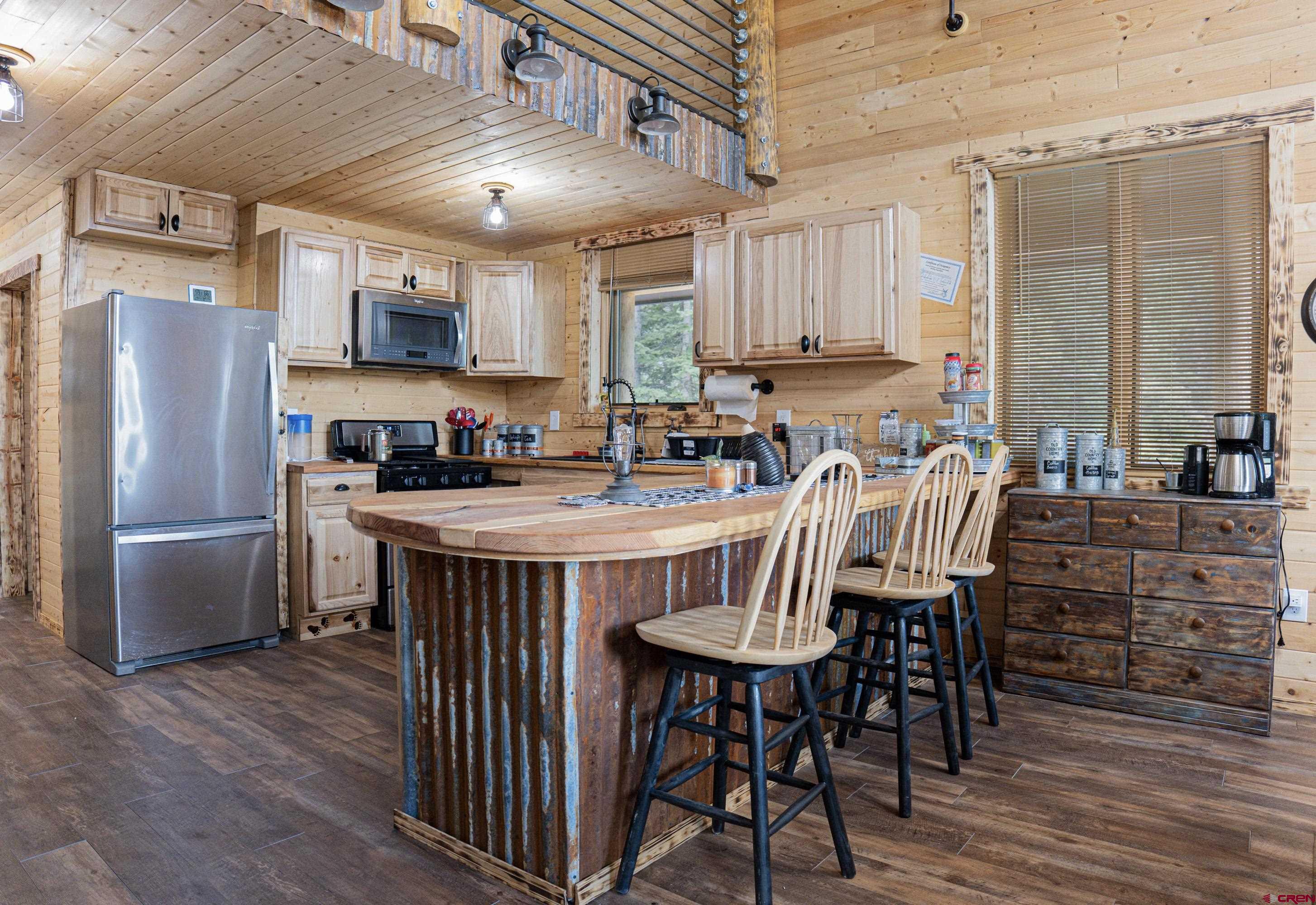 3300 County Road Silverton, CO 81433 - Photo 9 of 30 a kitchen with stainless steel appliances a table chairs refrigerator and sink